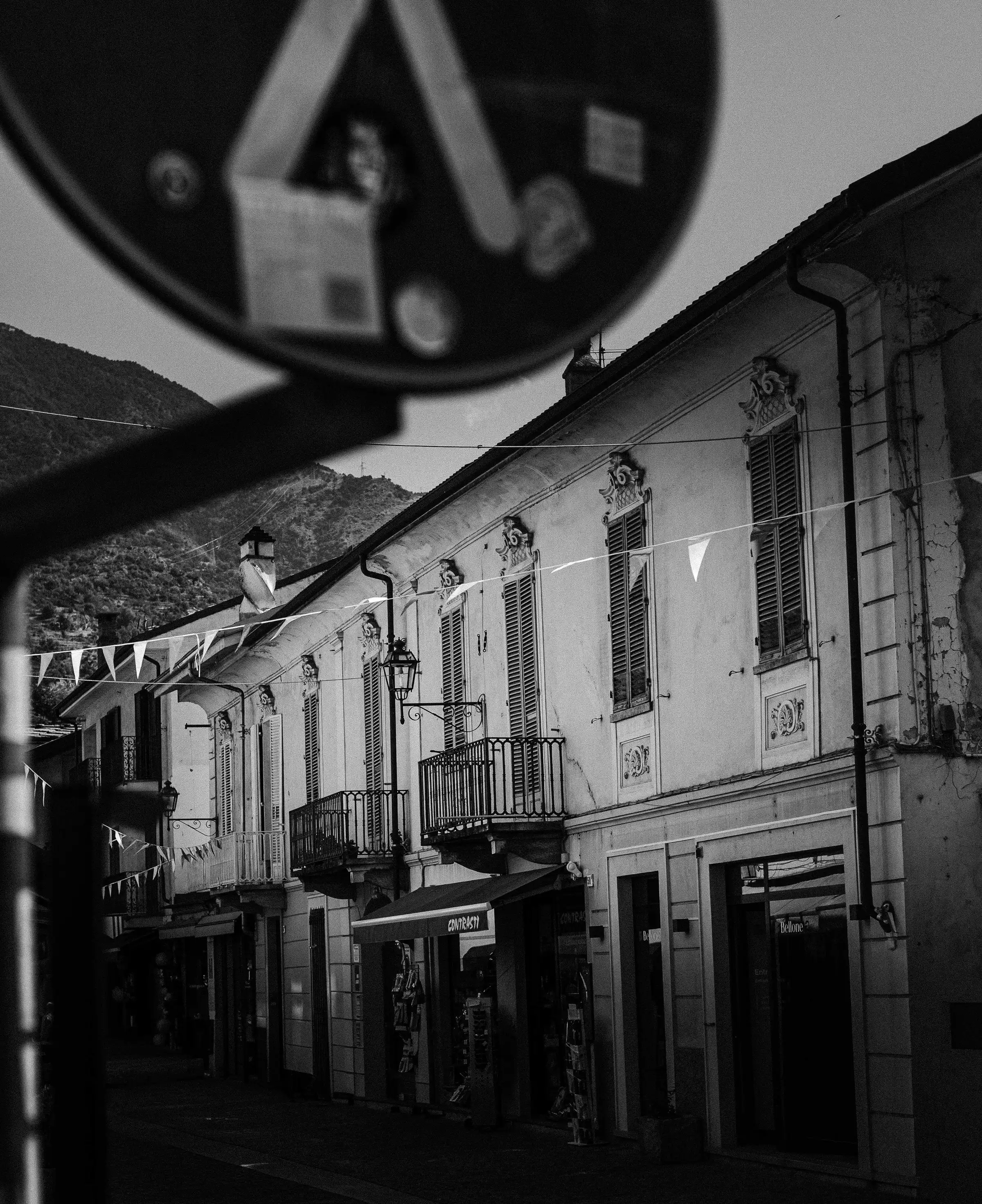 Photographie d'architecture — façade historique italienne à Suza, pierres anciennes et ombres contrastées, noir et blanc